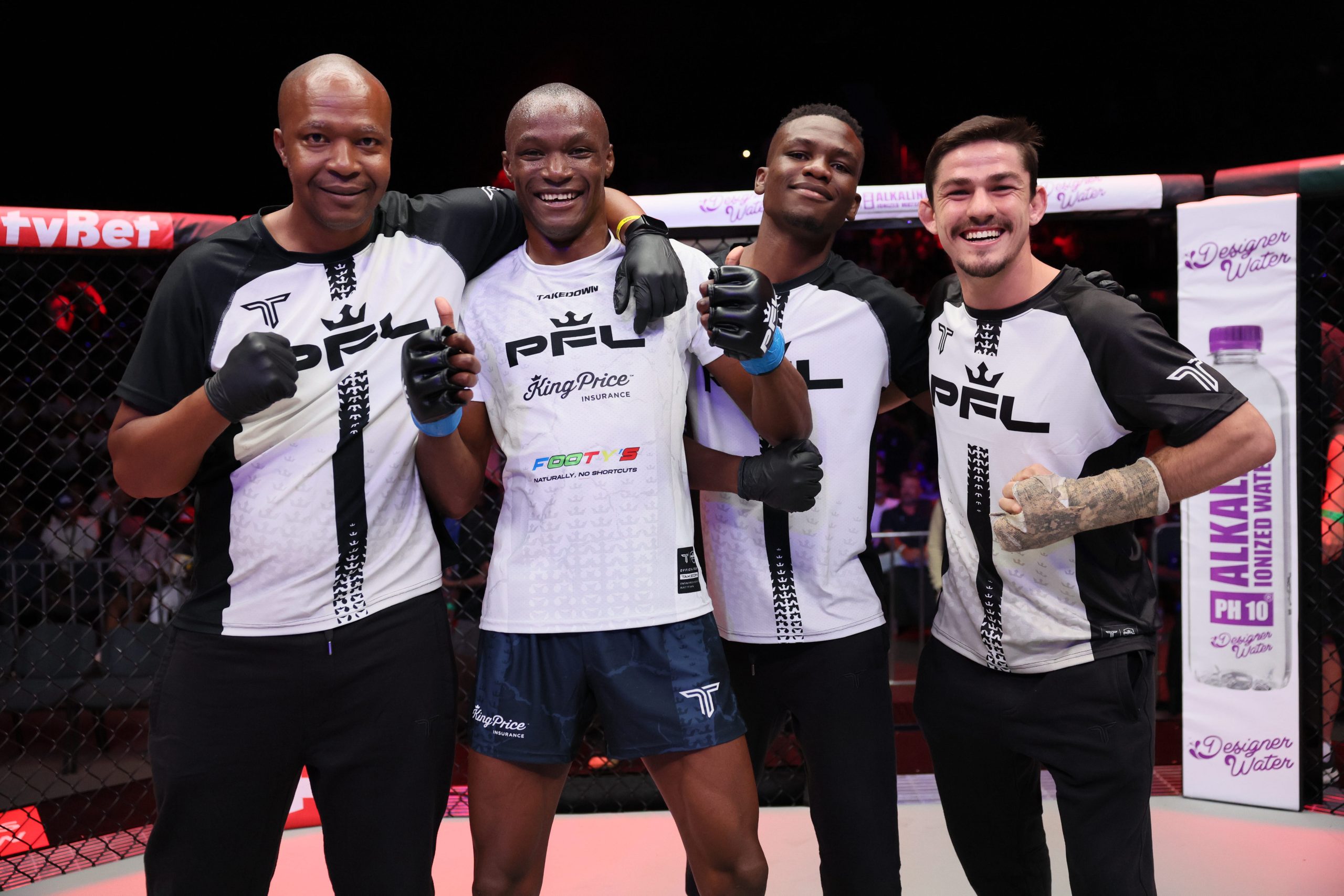 Fighter and PFL officials posing together and smiling inside the MMA octagon