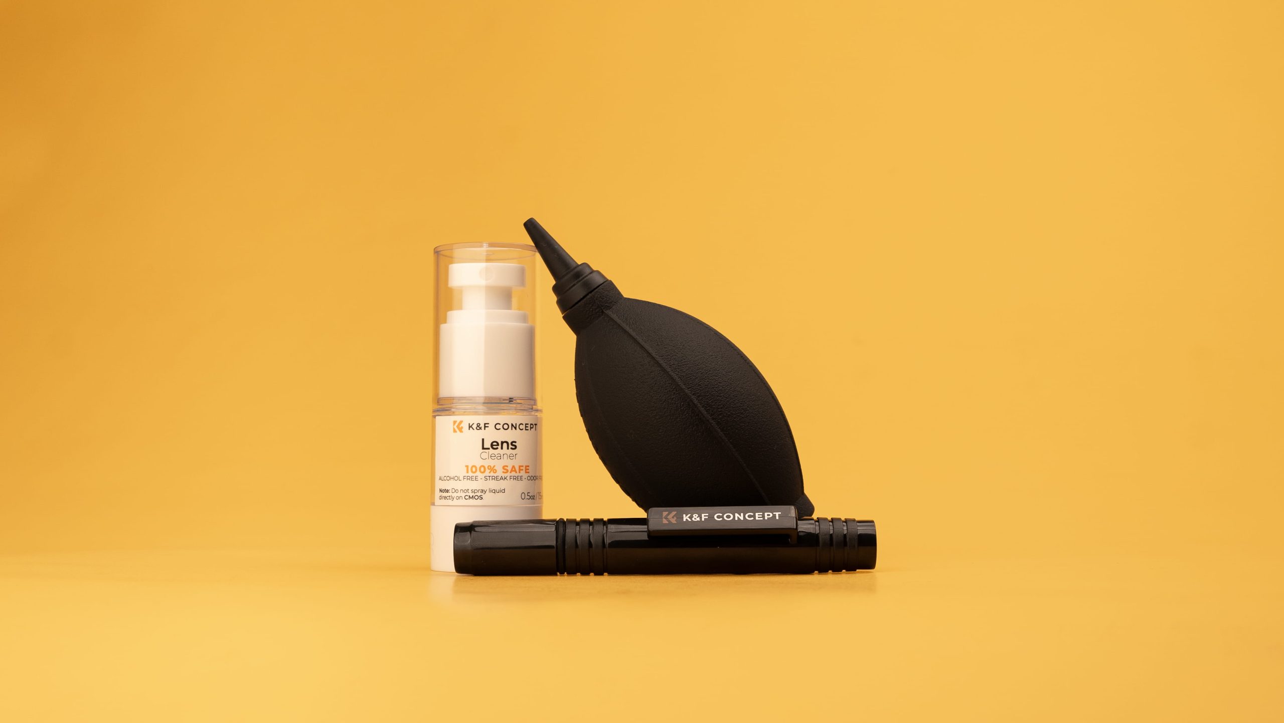 K&F Concept lens cleaner spray, rubber air blower, and cleaning pen on yellow